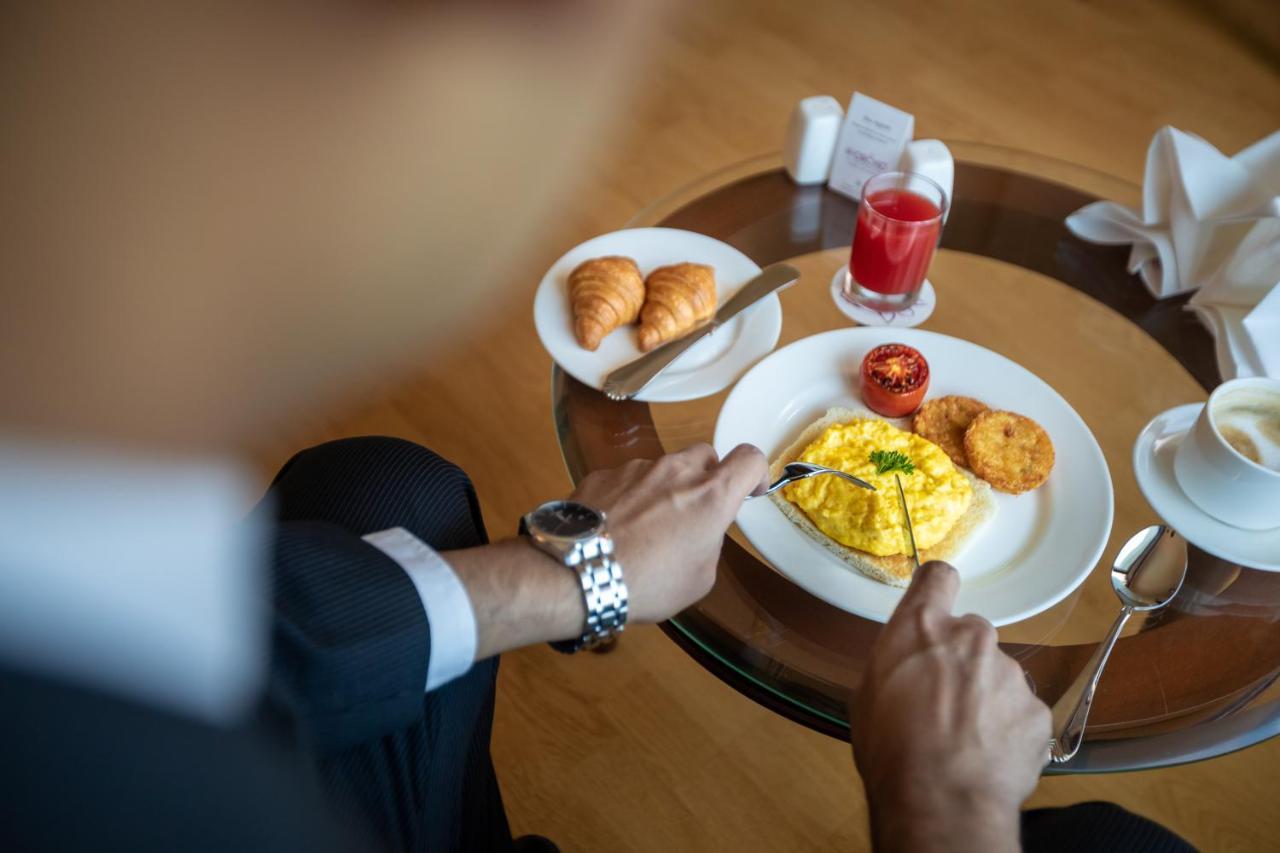 The Orchid Hotel Mumbai Vile Parle Kültér fotó A man eating breakfast